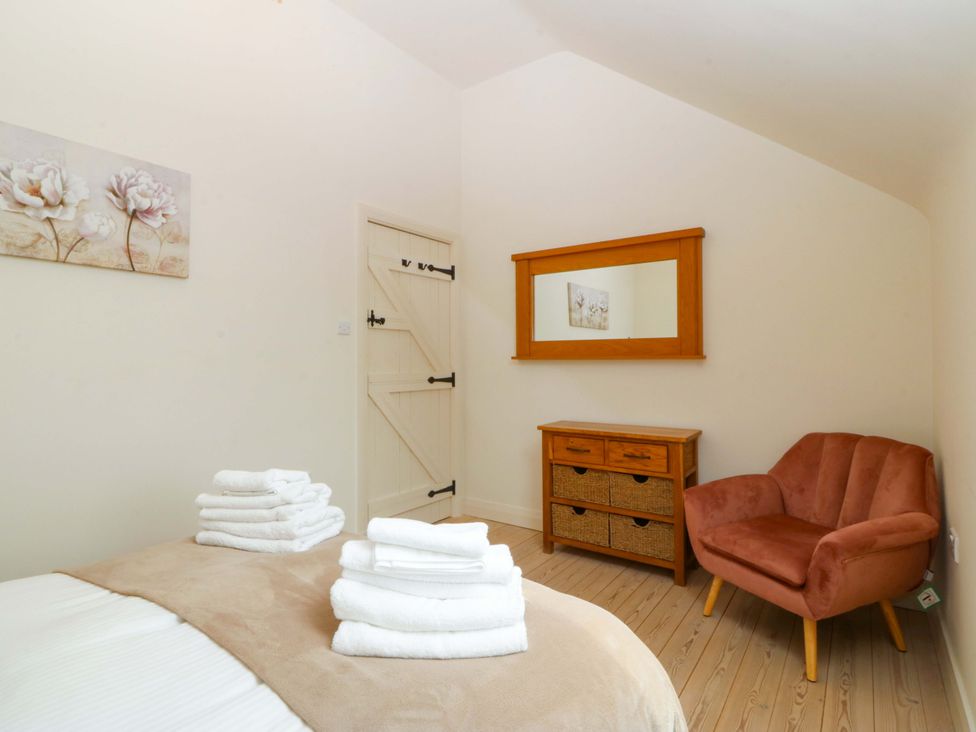 A bedroom with fresh towels on the bed at No 2 The Stables Capel Coch near Llannerch-Y-Medd