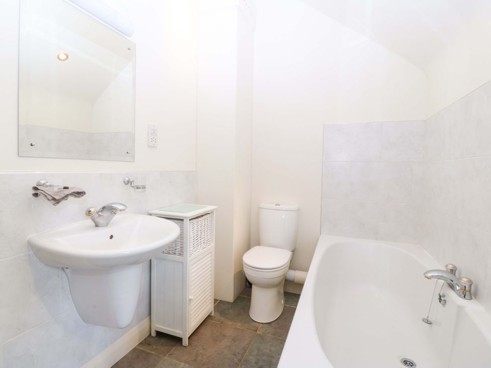 A bathroom featuring a sink, toilet, and bathtub at No 2 The Stables Capel Coch near Llannerch-Y-Medd