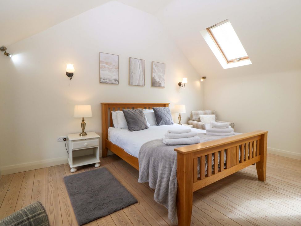 A bedroom with a bed and bedside table at No 2 The Stables Capel Coch near Llannerch-Y-Medd