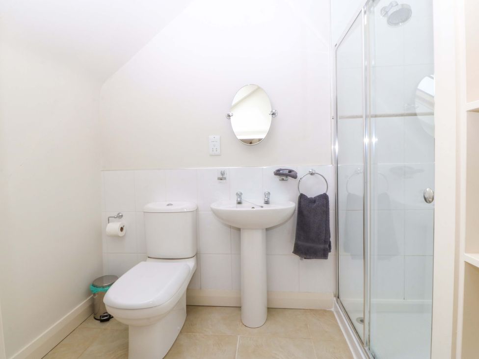A bathroom with a shower, sink, and toilet at No 2 The Stables in Capel Coch near Llannerch-Y-Medd