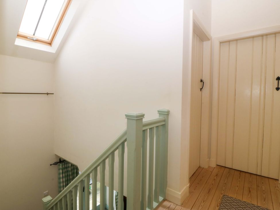 A staircase with a skylight and door at No 2 The Stables Capel Coch near Llannerch-Y-Medd