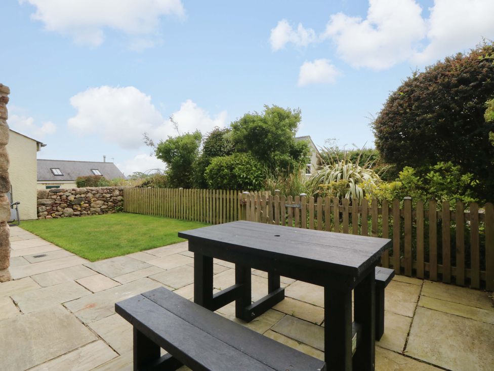 A garden with a table and benches at No 2 The Stables Capel Coch near Llannerch-Y-Medd