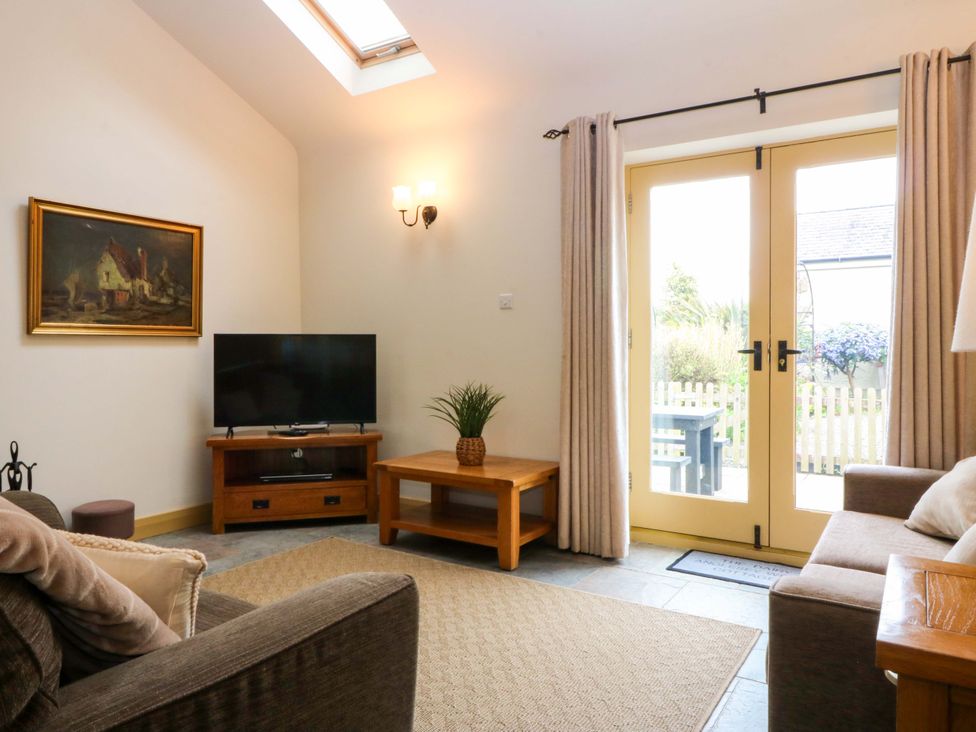 A living room with a television and coffee table at No 3 The Dairy near Llannerch-Y-Medd
