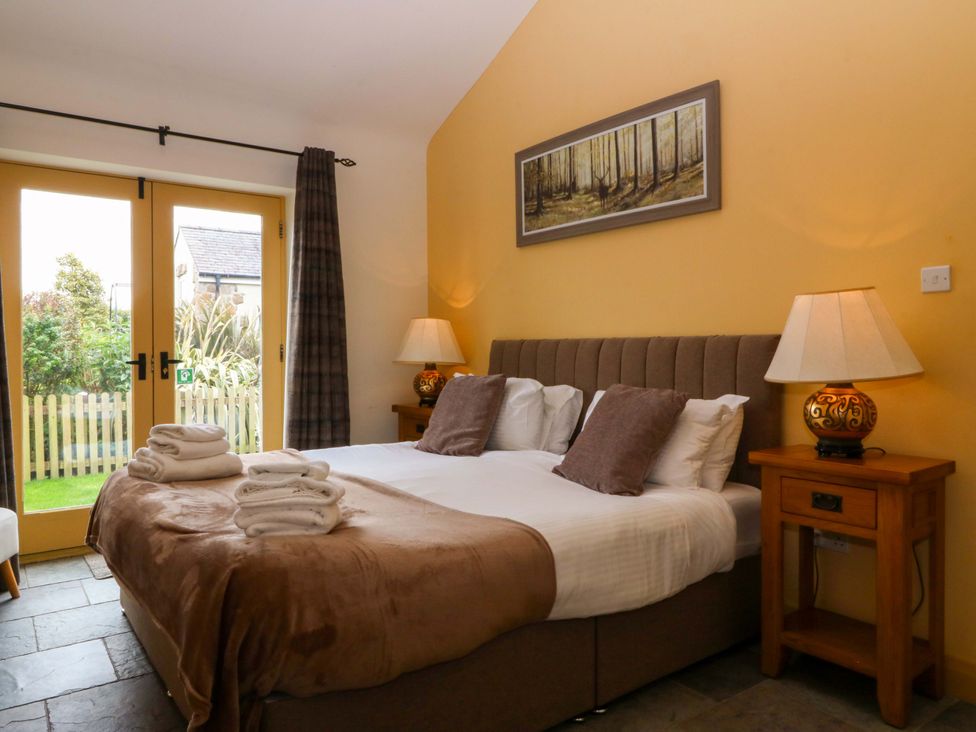 A bedroom with a bed and bedside table at No 3 The Dairy Capel Coch near Llannerch-Y-Medd