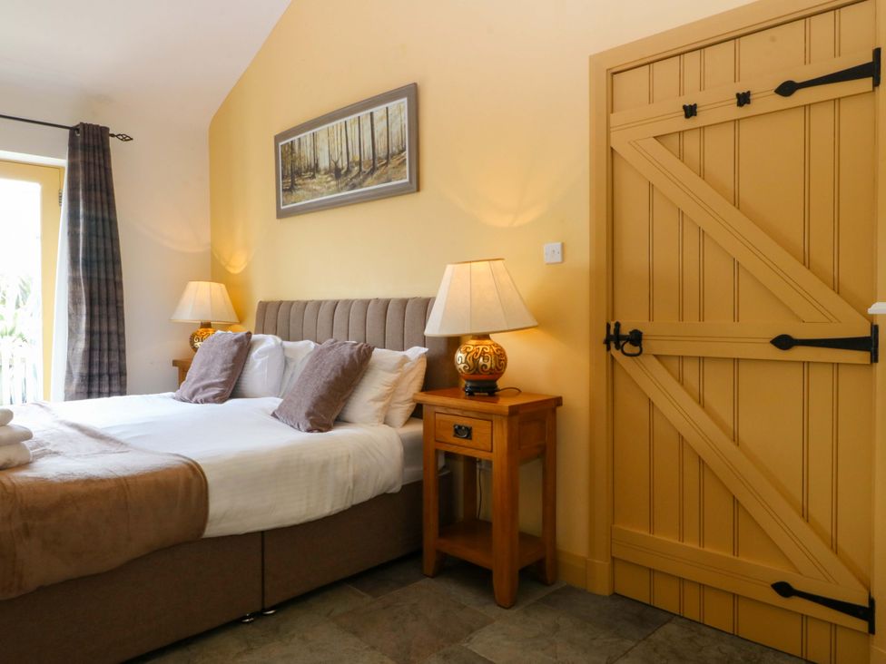 A bedroom with a bed and lamp at No 3 The Dairy in Capel Coch near Llannerch-Y-Medd
