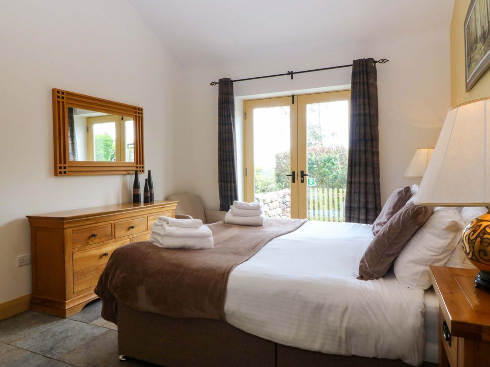 A bedroom with a bed and dresser at No 3 The Dairy Capel Coch near Llannerch-Y-Medd