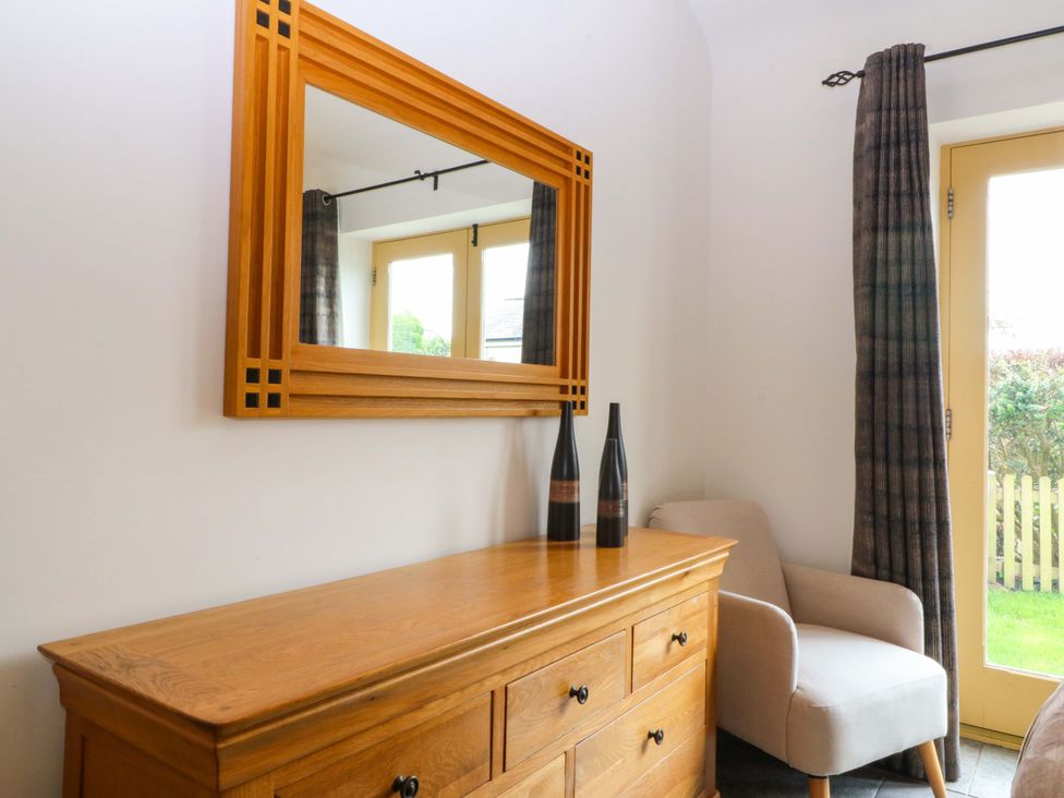 An entrance hall with a mirror and dresser at No 3 The Dairy Capel Coch near Llannerch-Y-Medd