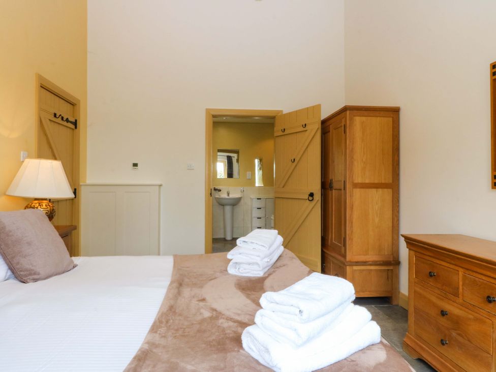 A bedroom with a bed and towels on it at No 3 The Dairy Capel Coch near Llannerch-Y-Medd