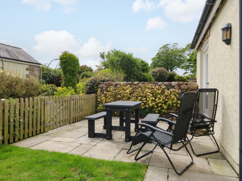 A garden area with a table and chairs at No 3 The Dairy Capel Coch near Llannerch-Y-Medd