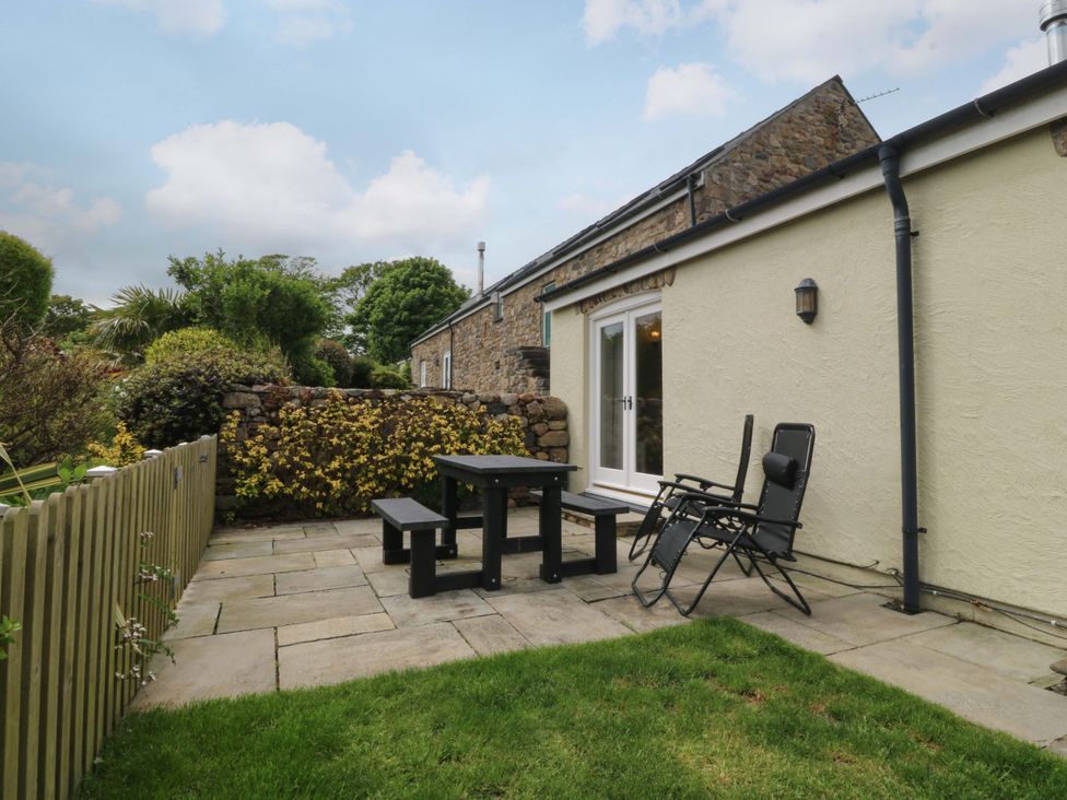 A garden patio with a table and chairs at No 3 The Dairy Capel Coch near Llannerch-Y-Medd
