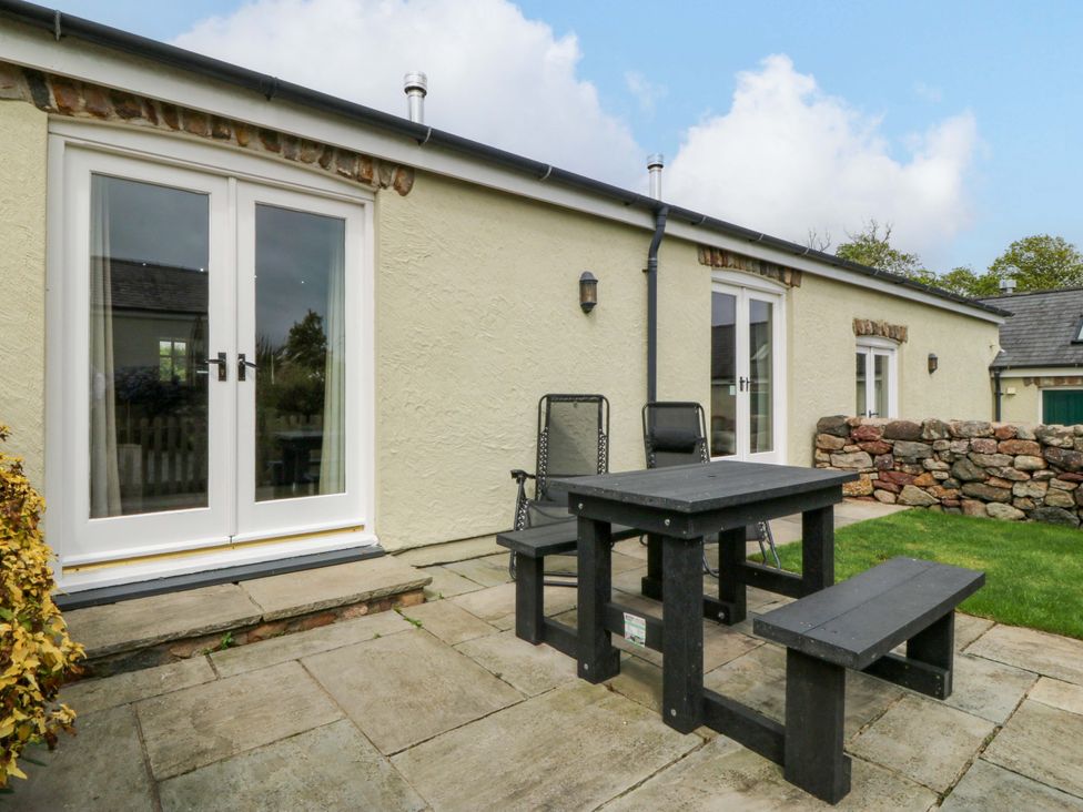 A patio with a table and chairs at No 3 The Dairy Capel Coch near Llannerch-Y-Medd
