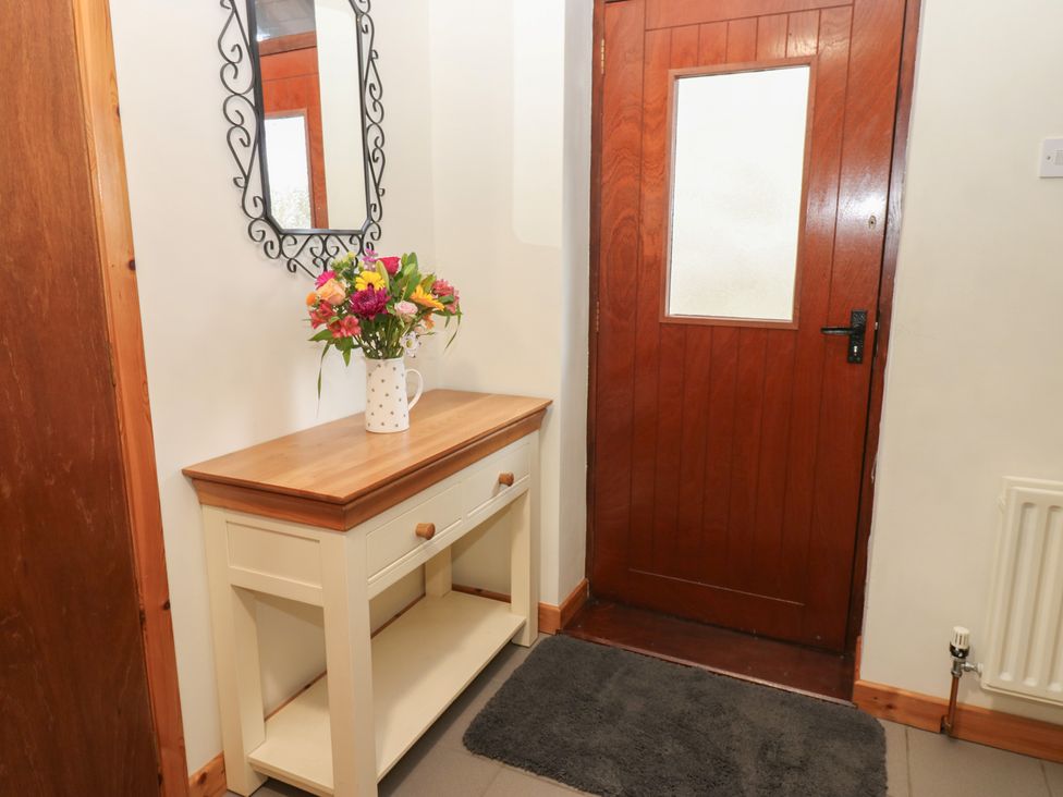 A hallway with a table and flowers at Summerseat in Kirkby Stephen
