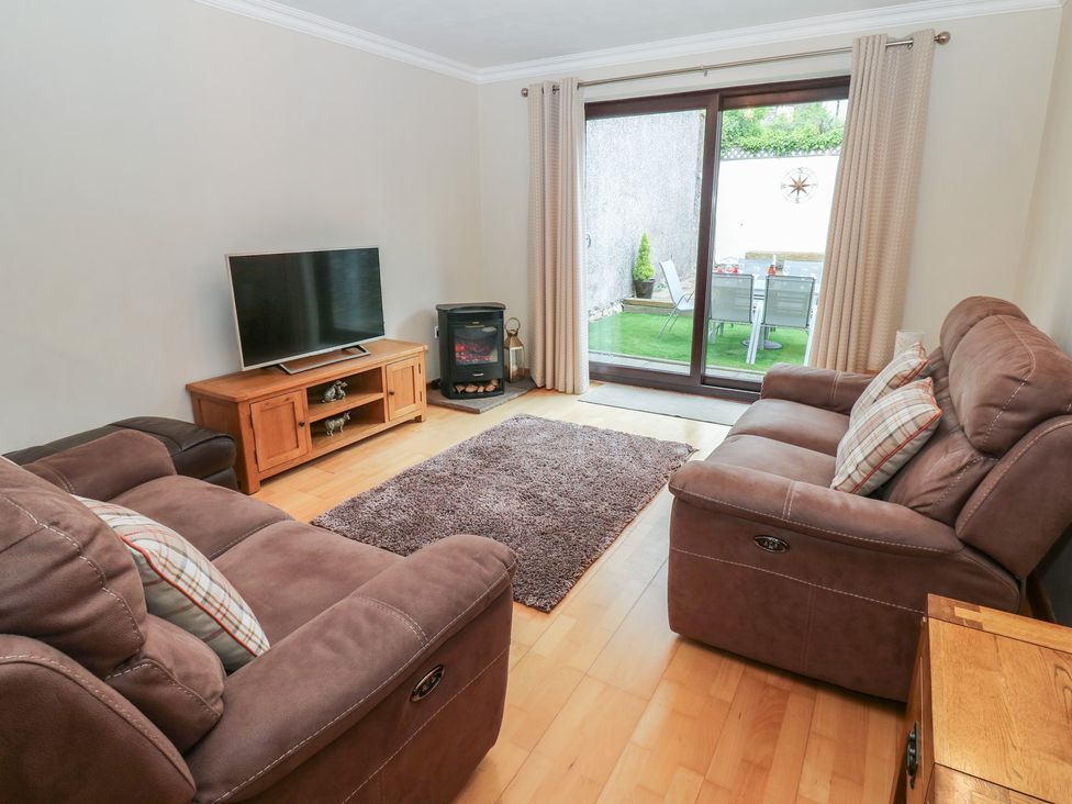 A living room with a television and sofa at Summerseat in Kirkby Stephen