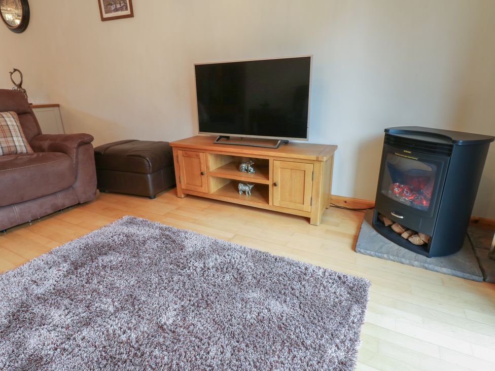 A living room with a television and fireplace at Summerseat in Kirkby Stephen
