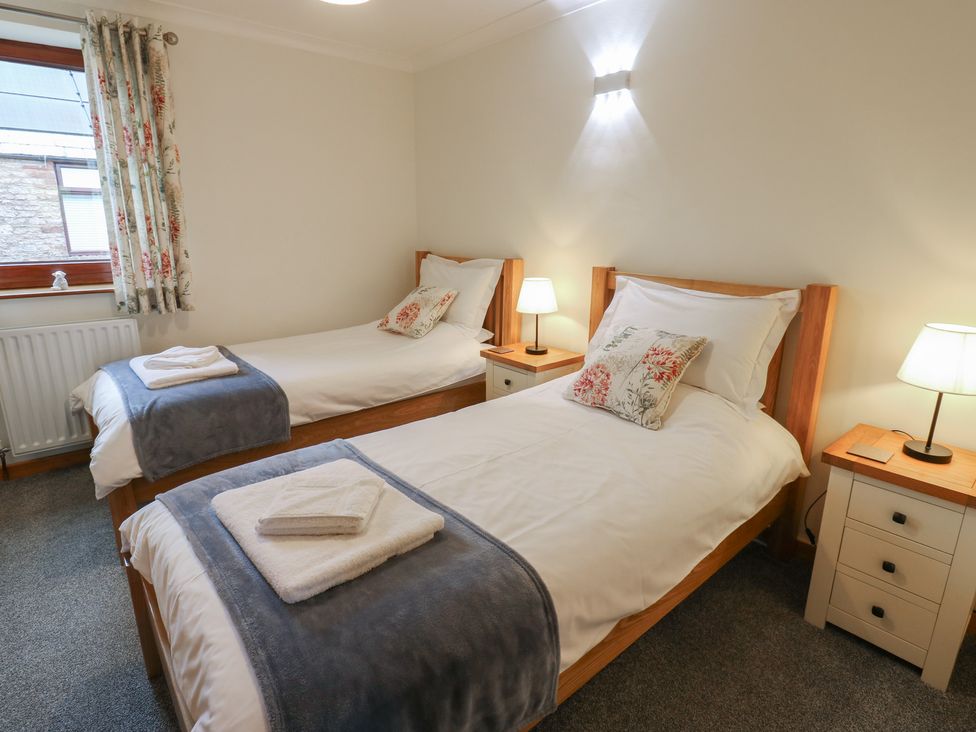 A bedroom with two single beds and bedside tables at Summerseat in Kirkby Stephen
