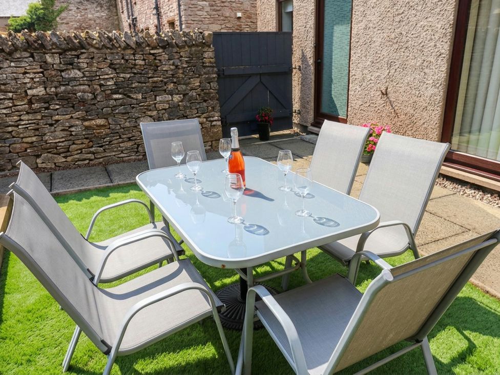An outdoor seating area with a table and chairs at Summerseat in Kirkby Stephen