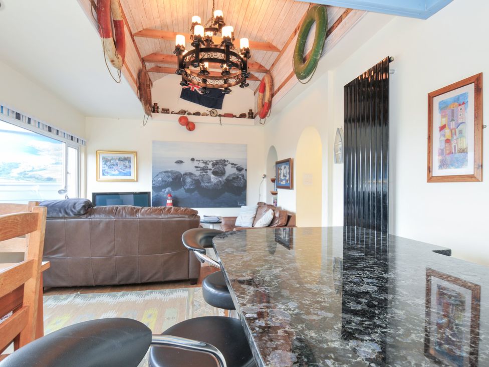 A living room with a sofa and a bar counter at Beachside in Polzeath