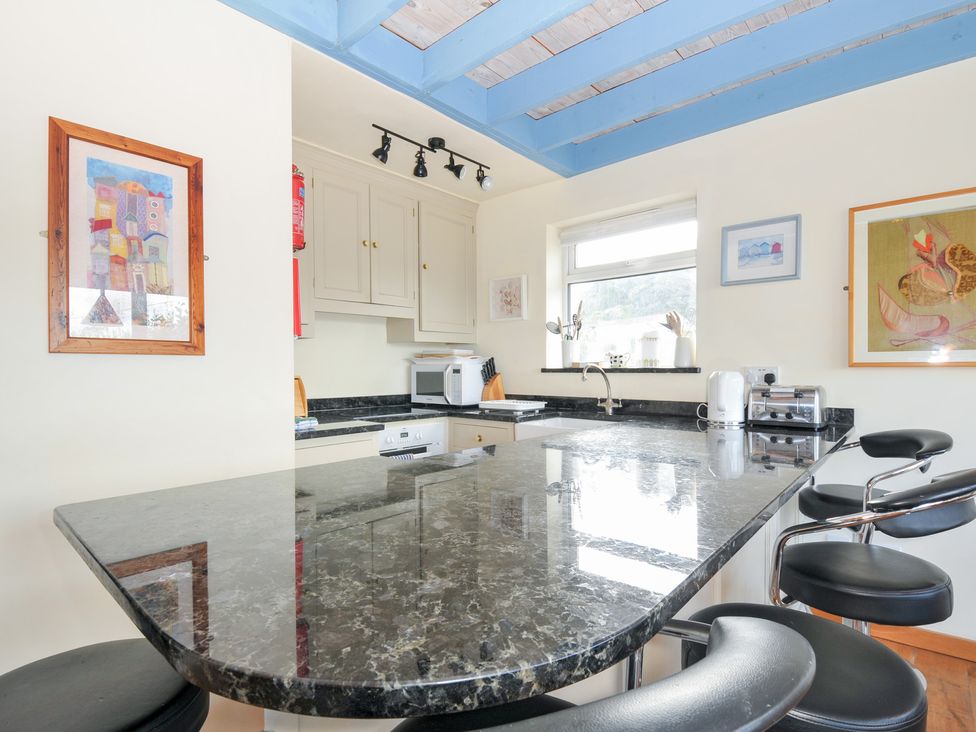 A kitchen with a countertop and bar stools at Beachside in Polzeath