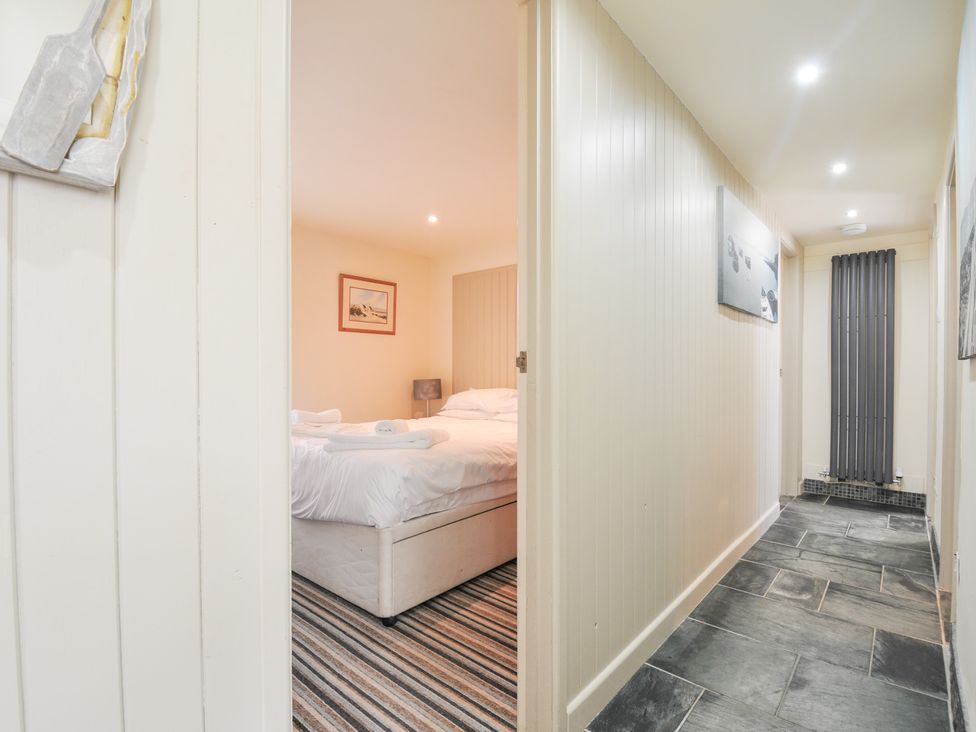 A hallway leading to a bedroom with a bed at Beachside in Polzeath