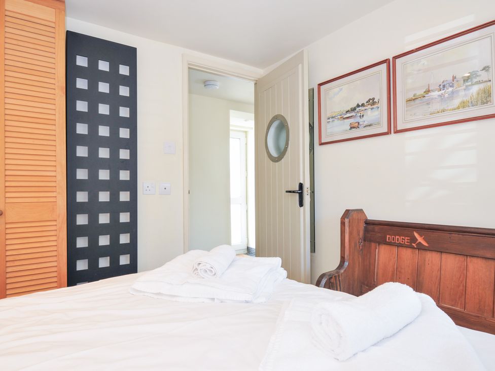 A bedroom with a bed and towels at Beachside in Polzeath