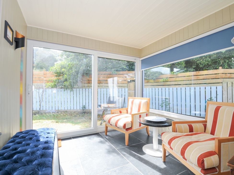 A conservatory with chairs and a table at Beachside in Polzeath