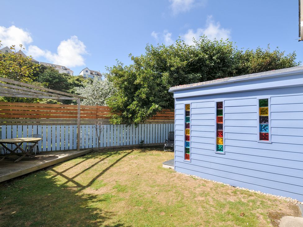 A garden with a shed and seating area at Beachside in Polzeath