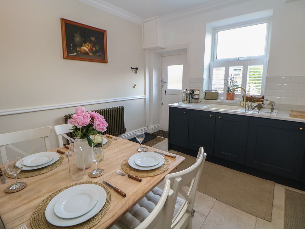 A dining room with a table set for meals at 16 Oak Bank in Stockport