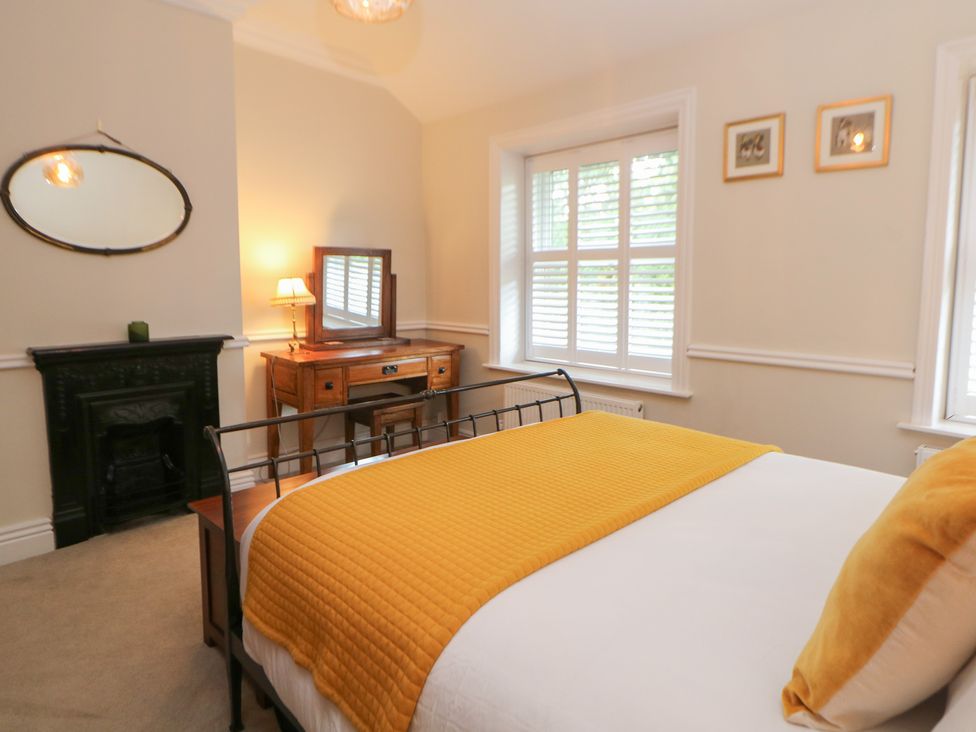 A bedroom with a bed, dresser, and fireplace at 16 Oak Bank in Stockport