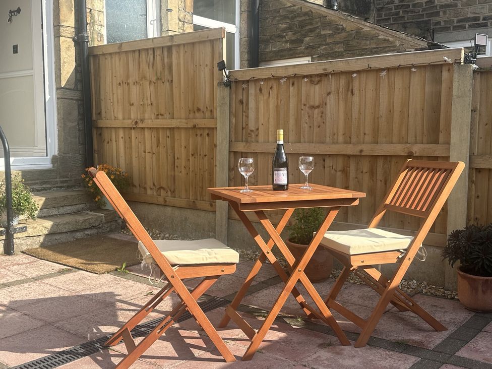An outdoor dining area with a table and chairs at 16 Oak Bank in Newtown near New Mills