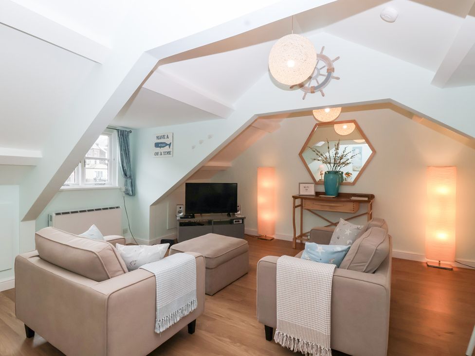 A living room with sofa and television at Smugglers Loft in Looe