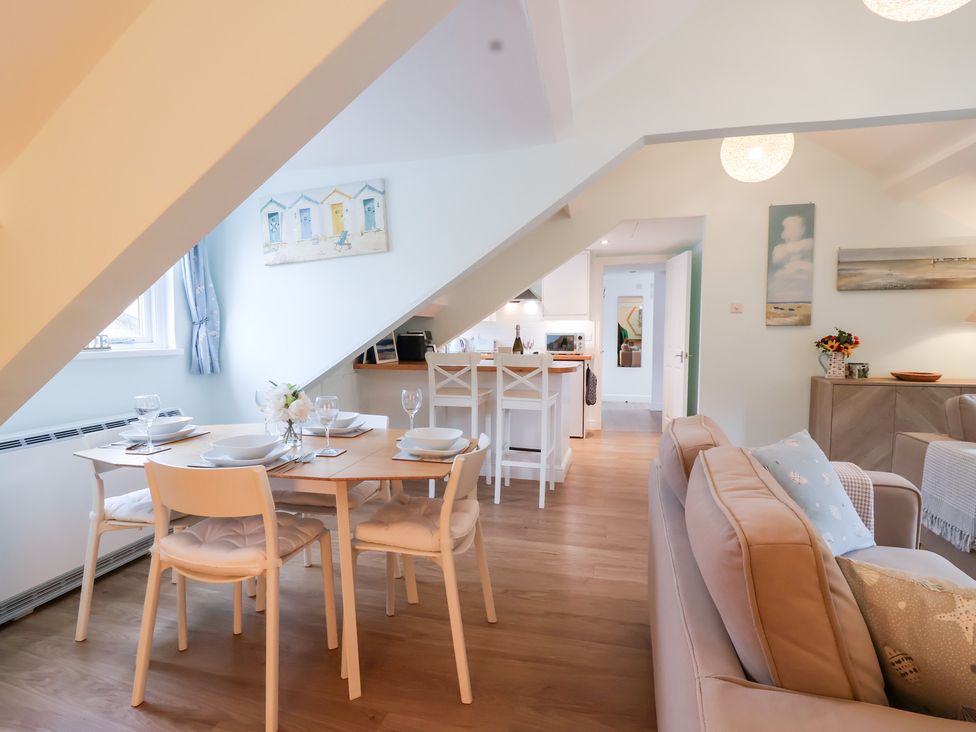 An open plan living area with dining table and kitchen at Smugglers Loft Looe