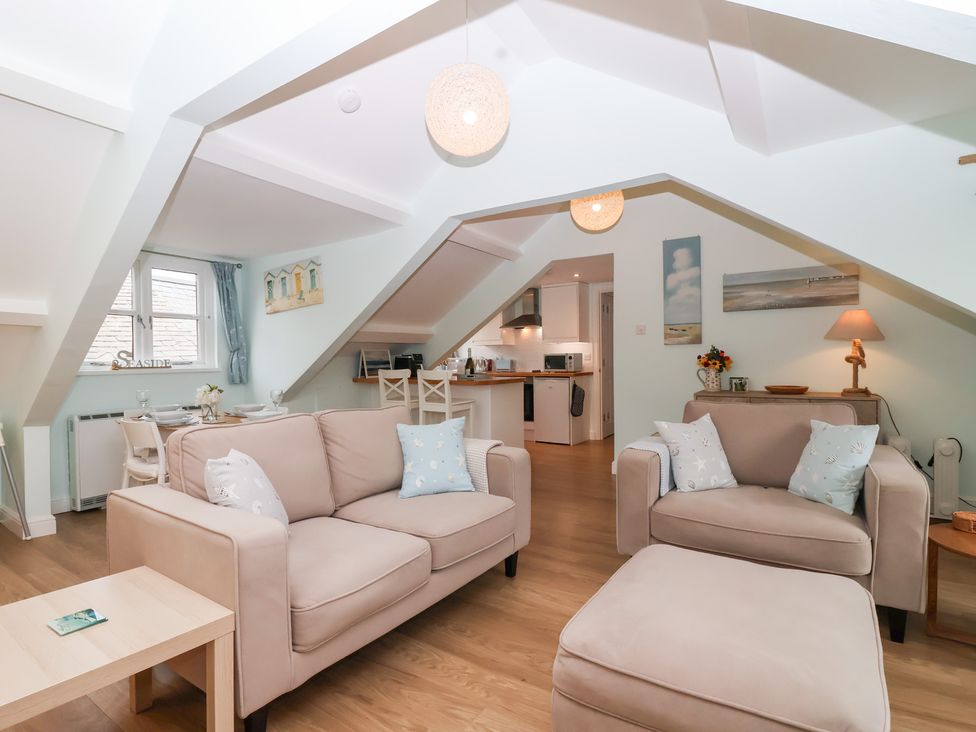 A living room with sofas and a dining area at Smugglers Loft in Looe