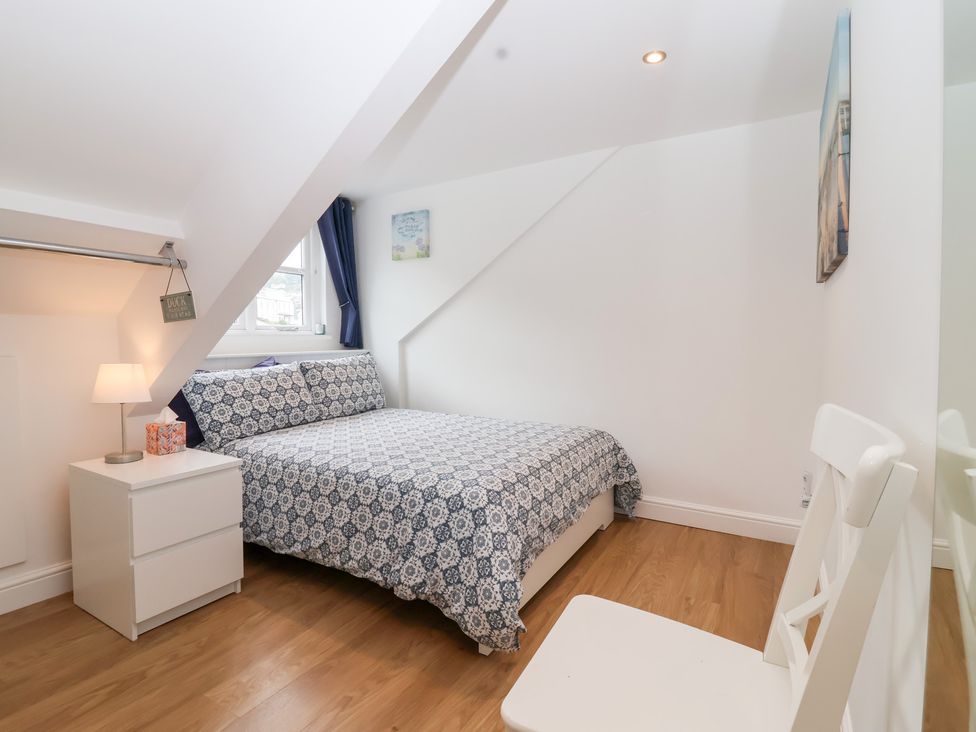 A bedroom with a bed and bedside table at Smugglers Loft in Looe