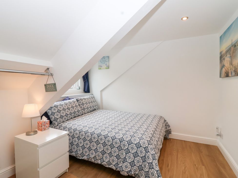A bedroom with a bed and bedside table at Smugglers Loft in Looe