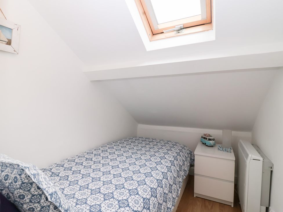 A bedroom with a bed and nightstand at Smugglers Loft in Looe