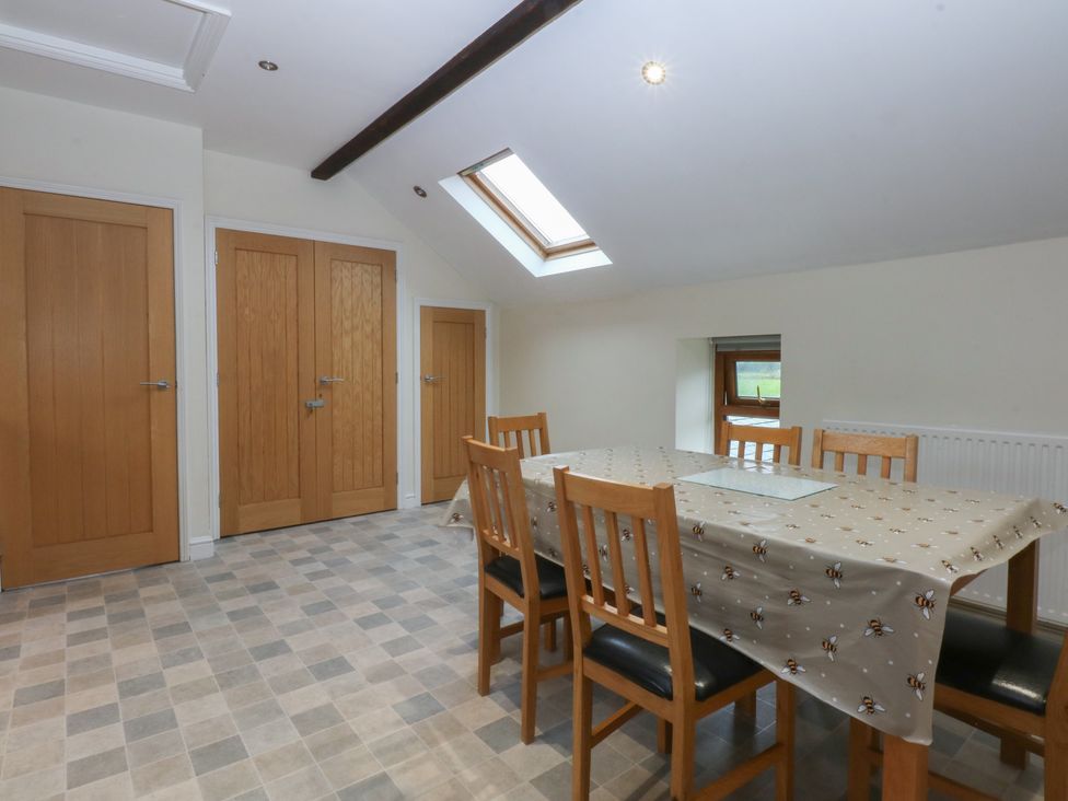 A dining room with a table and chairs at Llofft Yr Yd in Porthmadog
