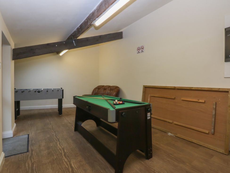 A game room with a pool table and foosball table at Llofft Yr Yd in Porthmadog