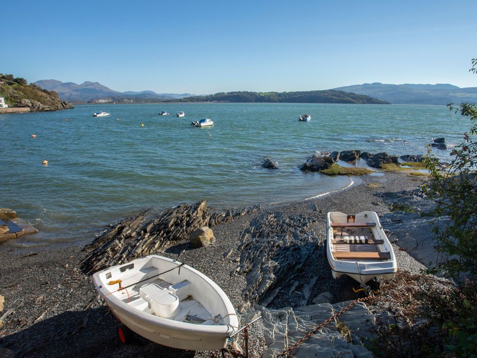 A view of boats on water near rocky shoreline at Llofft Yr Yd in Porthmadog
