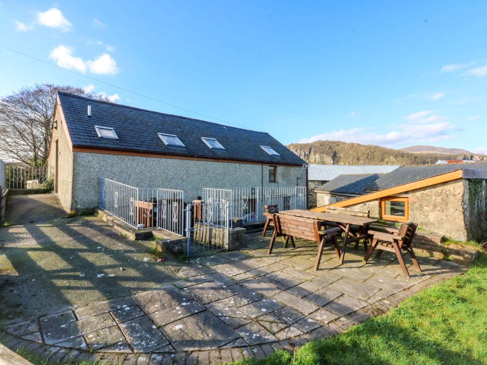 An outdoor area with a table and chairs at Llofft Yr Yd in Porthmadog