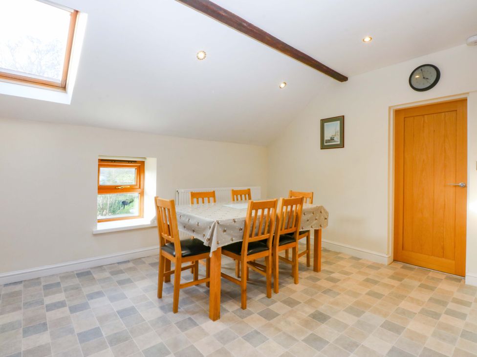 A dining room with a table and chairs at Llofft Yr Yd in Porthmadog