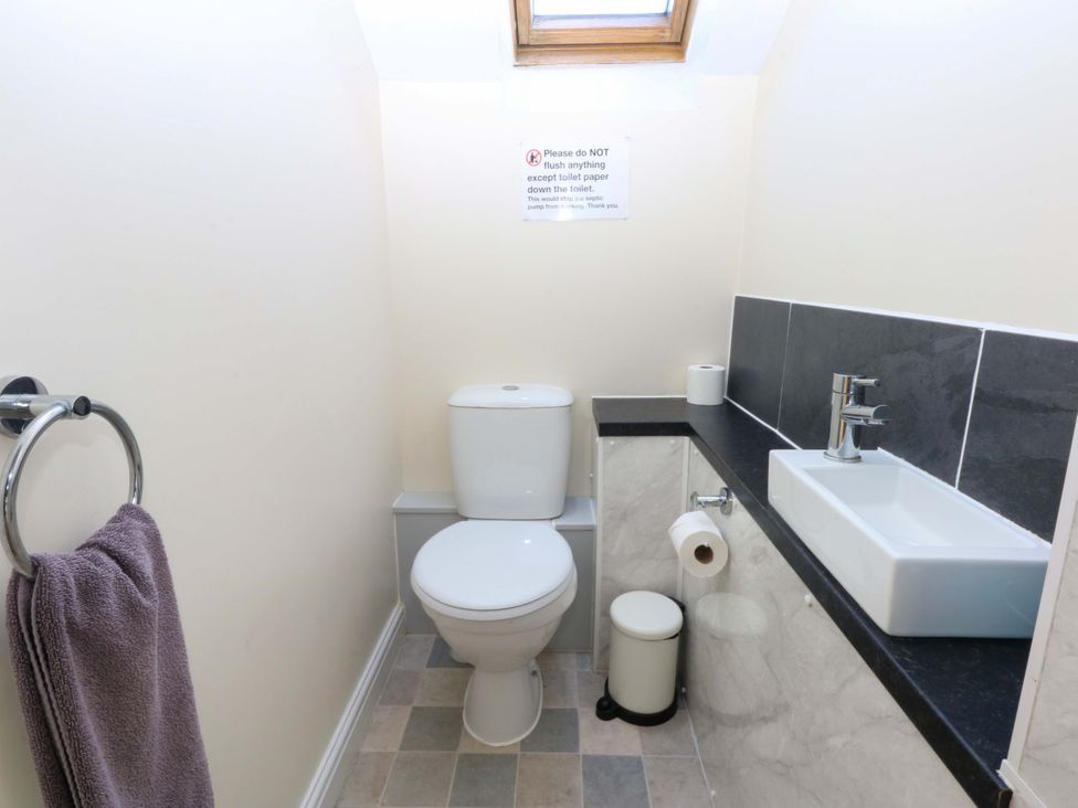 A bathroom with a toilet and sink at Llofft Yr Yd in Porthmadog