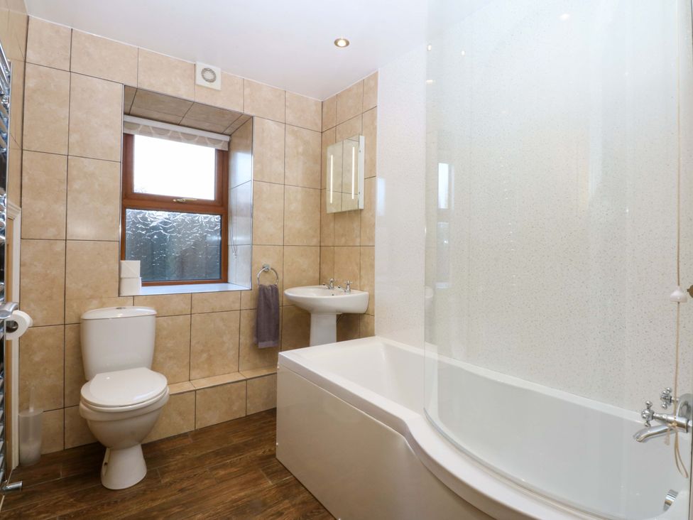 A bathroom with a bathtub and sink at Llofft Yr Yd in Porthmadog