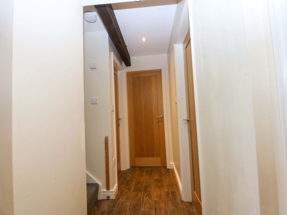 A hallway with doors on both sides and a staircase at Llofft Yr Yd in Porthmadog