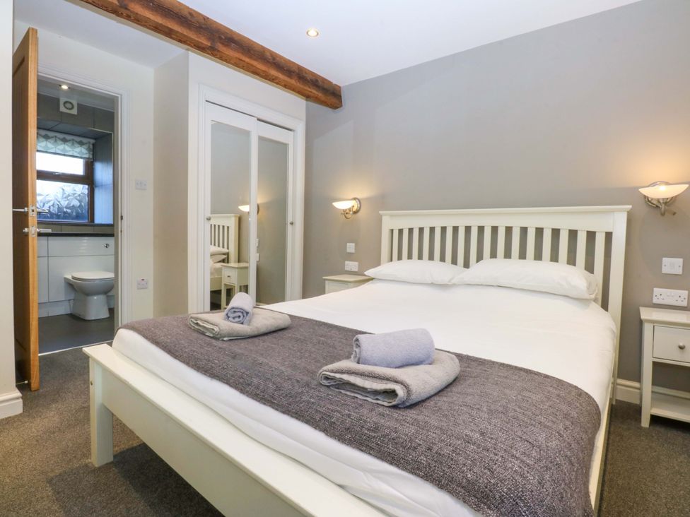 A bedroom with a bed and adjoining bathroom at Llofft Yr Yd in Porthmadog