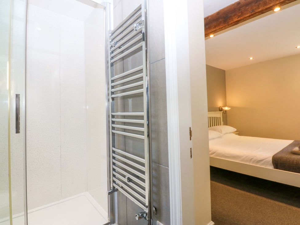 A bathroom with a shower and towel radiator at Llofft Yr Yd in Porthmadog