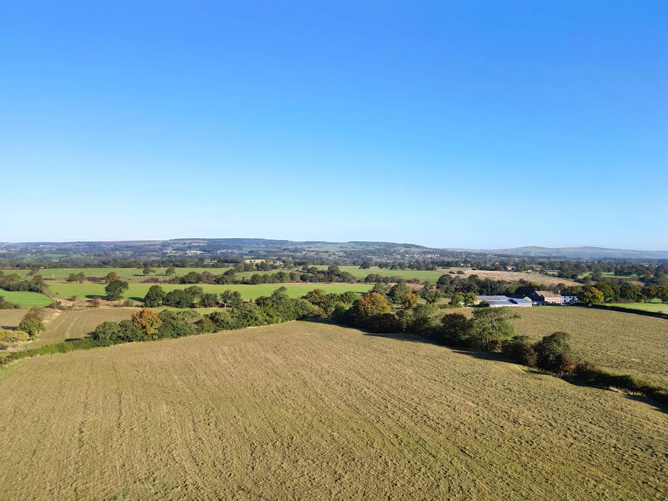 A view of fields and trees with hills in the background at Archstone House, Langho, Lancashire