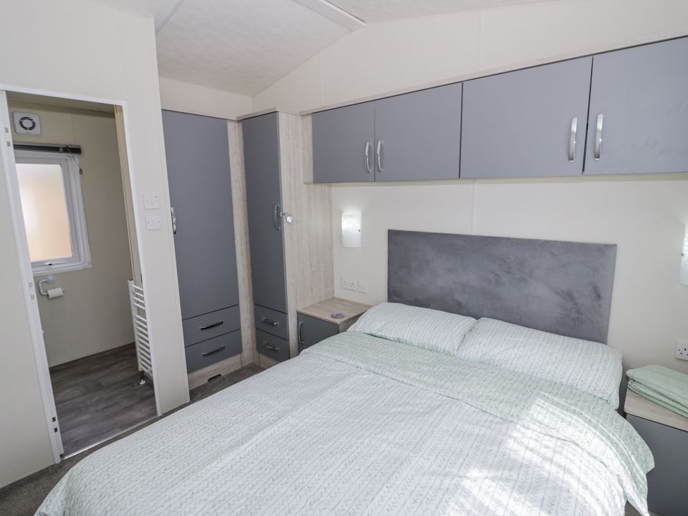 A bedroom with a bed and storage units at Serendipity