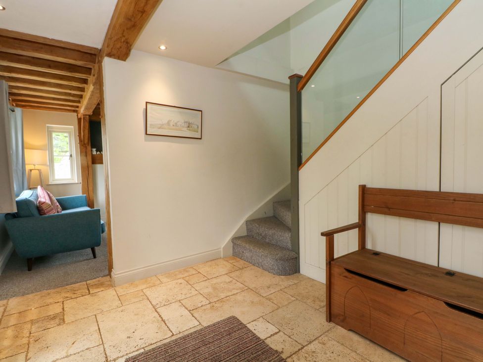 A hallway with stairs and a bench at Gayton Stables in Heswall