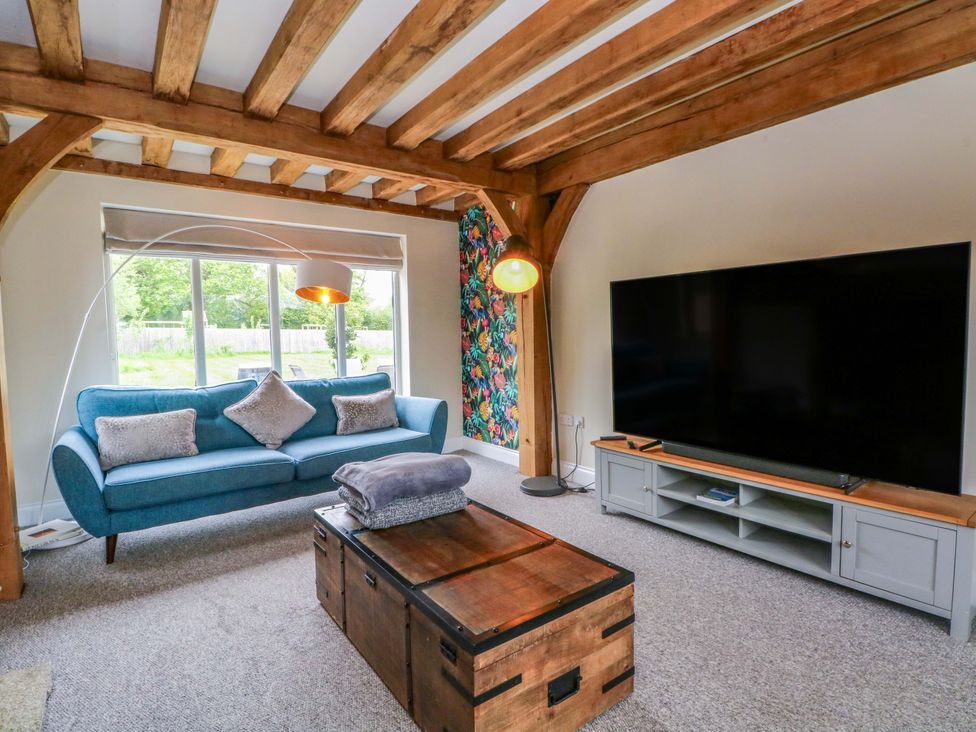 A living room with a sofa and television at Gayton Stables in Heswall