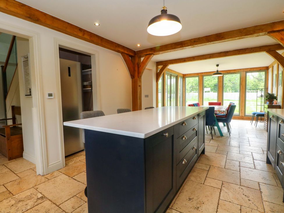 A kitchen with a large island and dining area at Gayton Stables in Heswall